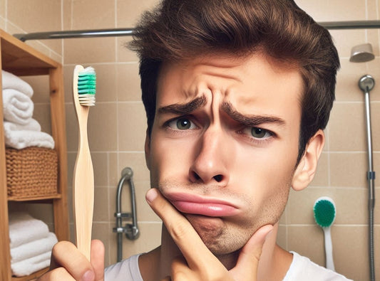 A confused person holding a bamboo toothbrush, thinking are bamboo toothbrushes actually better?